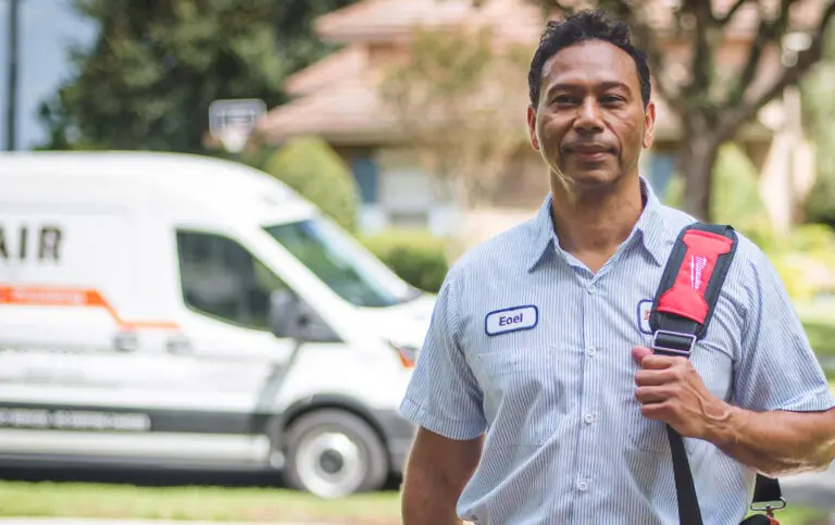A Del-Air technician standing outside a service van