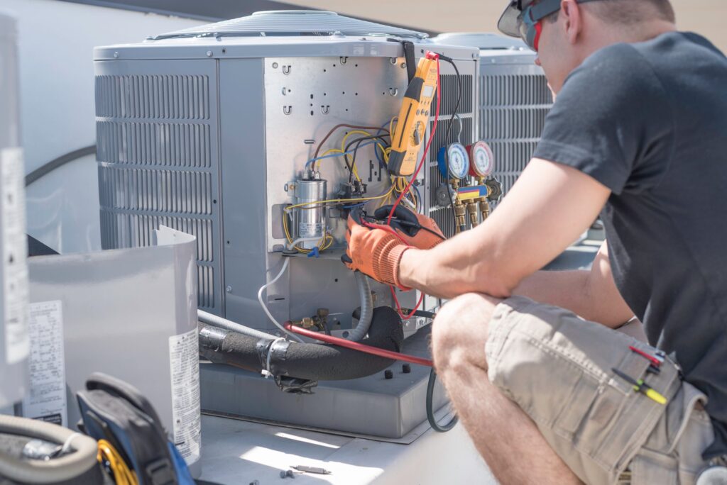A technician repairing an outdoor HVAC unit
