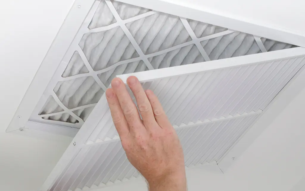 Hand changing an air conditioning unit filter.