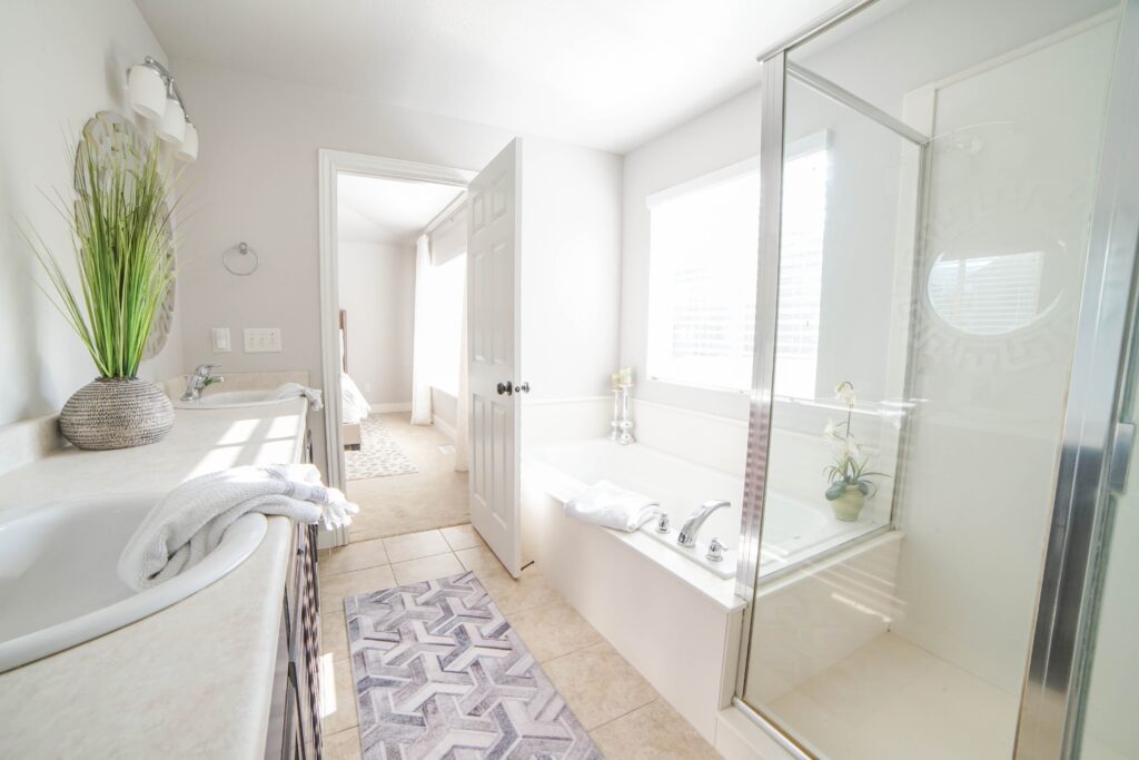 Picture of an all-white, modern bathroom, including a sink, bathtub, and glass shower.