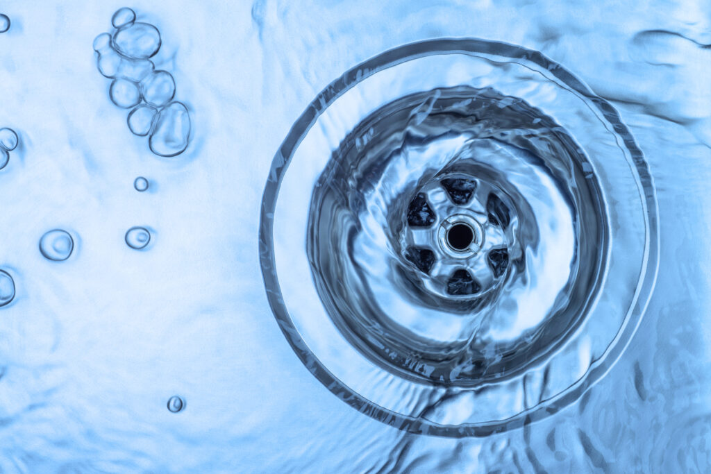 Kitchen sink with running water going down a drain