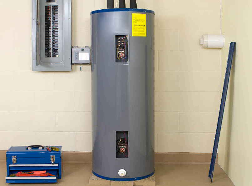 A traditional tank-style water heater newly installed in a cinderblock building