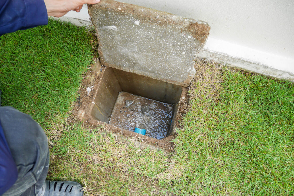 A worker opening the sewer cover of new house