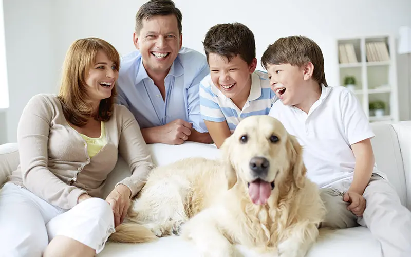 family sitting with dog on sofa