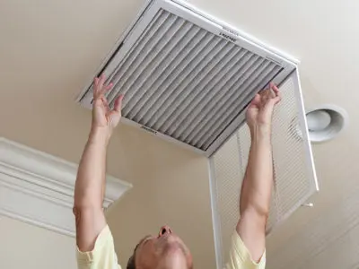 A senior man checking the air filter