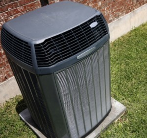 A heat pump on the ground outside a home